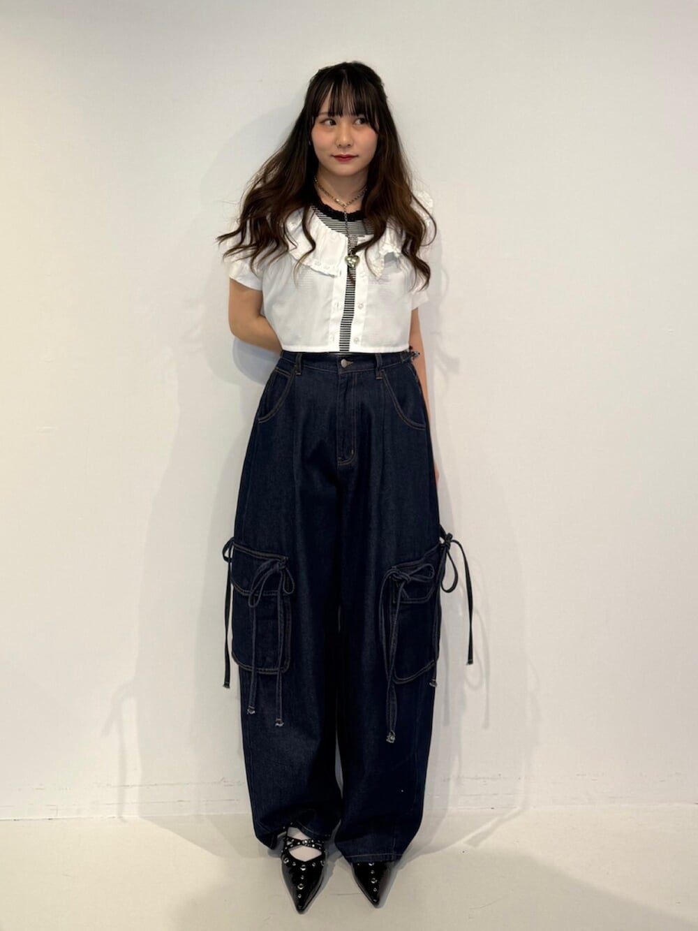ブラック系のパンプス、ホワイト系のシャツ/ブラウス、ブルー系のデニムパンツを着用したレディースの春コーディネートの2枚目の写真