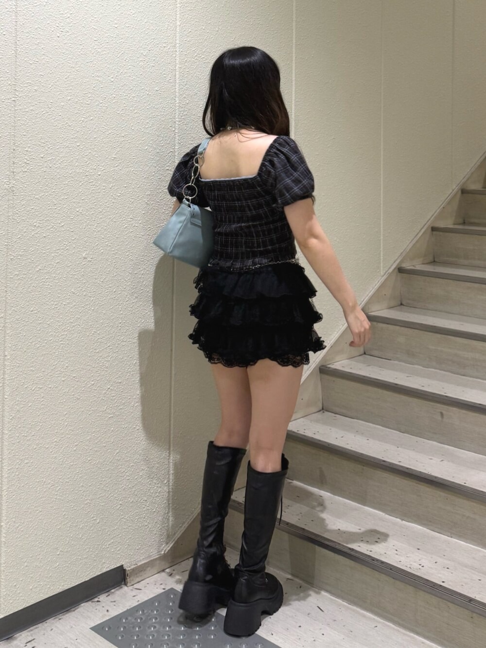 ブルー系のハンドバッグ、ブラック系のブーツ、ブラック系のその他パンツを着用したレディースの夏コーディネートの3枚目の写真