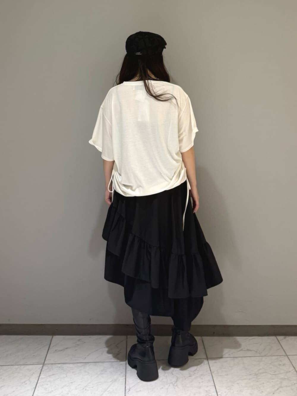 ブラック系のブーツ、ホワイト系のTシャツ/カットソー、ブラック系のスカートを着用したレディースの夏コーディネートの3枚目の写真