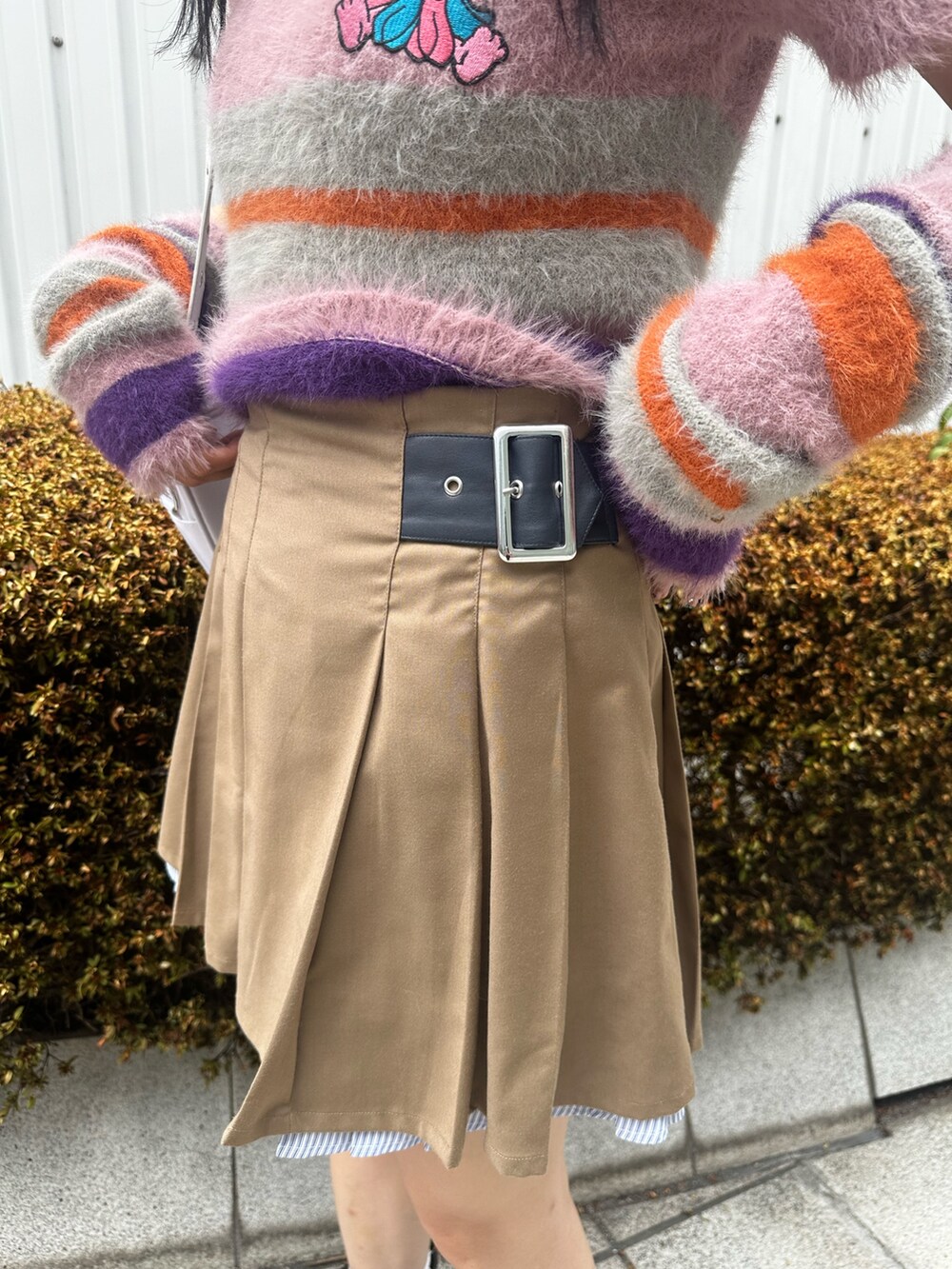 ピンク系のニット/セーター、ベージュ系のスカート、ホワイト系のショルダーバッグを着用したレディースの夏コーディネートの8枚目の写真