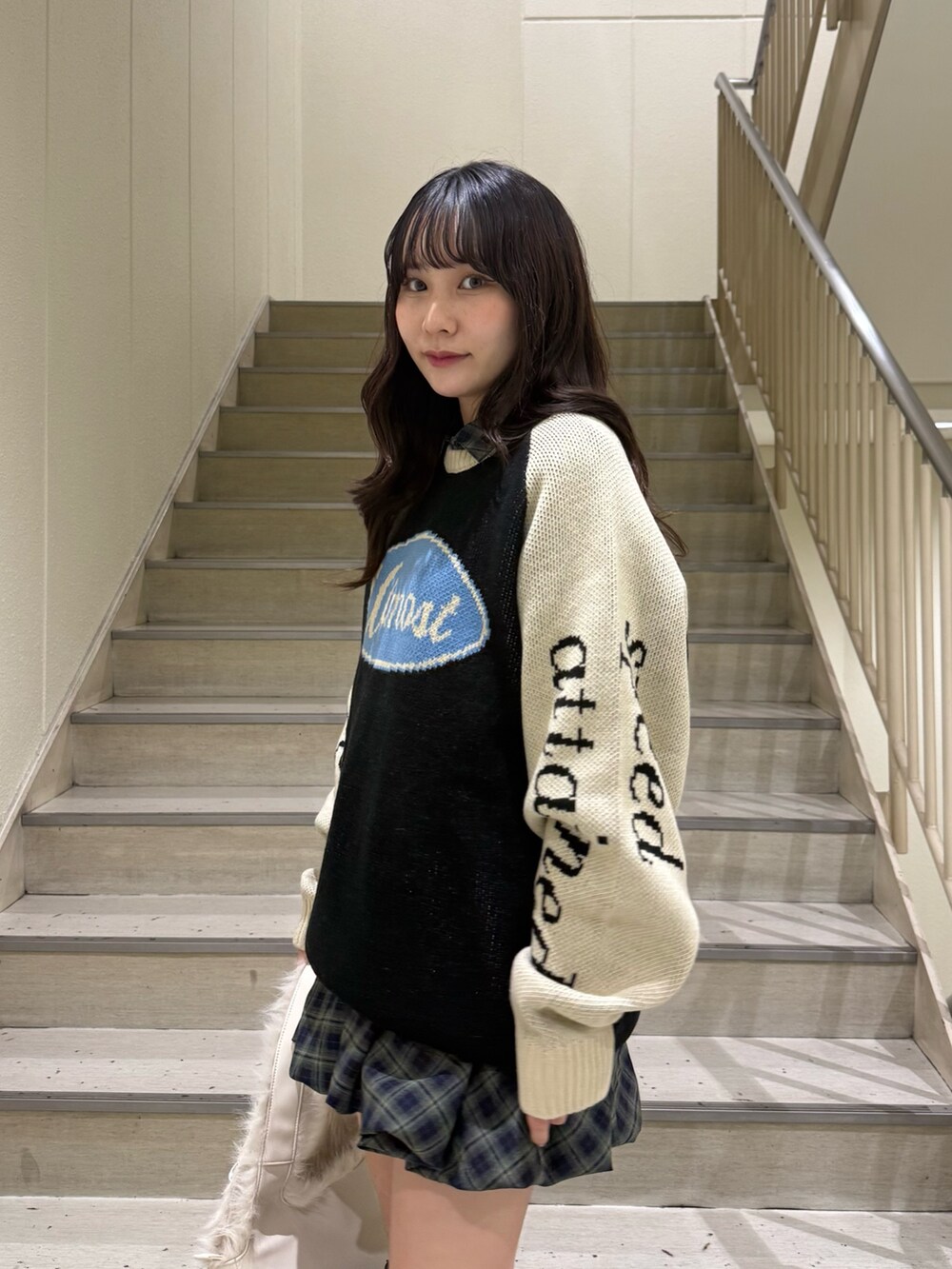 ブラック系のニット/セーター、グリーン系のワンピース、ホワイト系のハンドバッグを着用したレディースの冬コーディネートの7枚目の写真