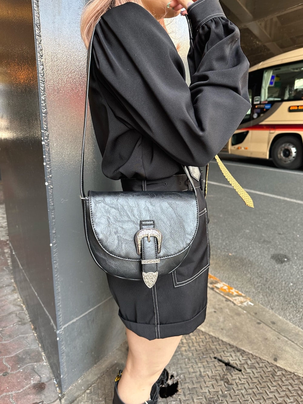 ブラック系のつなぎ/オールインワン、ブラック系のショルダーバッグ、ブラック系のブーツを着用したレディースの春コーディネートの5枚目の写真