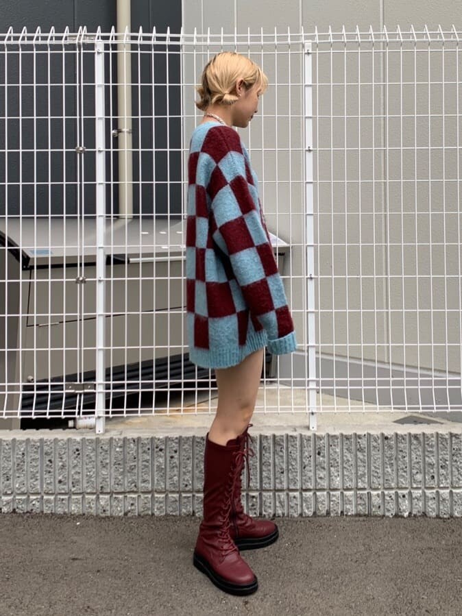 ブルー系のニット/セーター、レッド系のブーツを着用したレディースの秋コーディネートの3枚目の写真