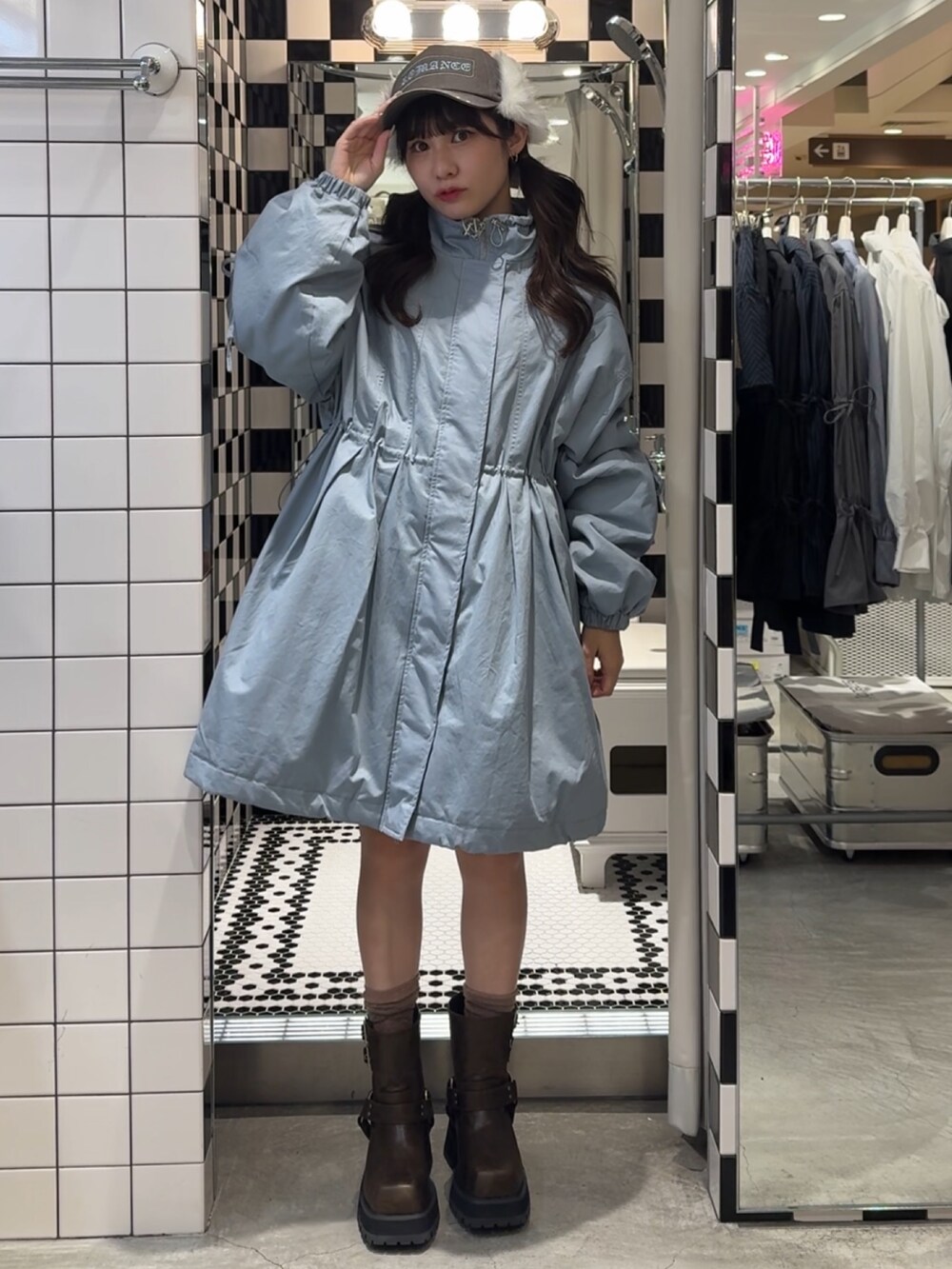 ブルー系のモッズコート、ブラウン系のブーツ、ブラウン系のキャップを着用したレディースの冬コーディネートの2枚目の写真