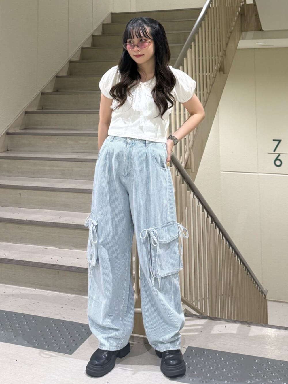 ブラック系のブーツ、ホワイト系のTシャツ/カットソー、ブルー系のデニムパンツを着用したレディースの春コーディネートの2枚目の写真