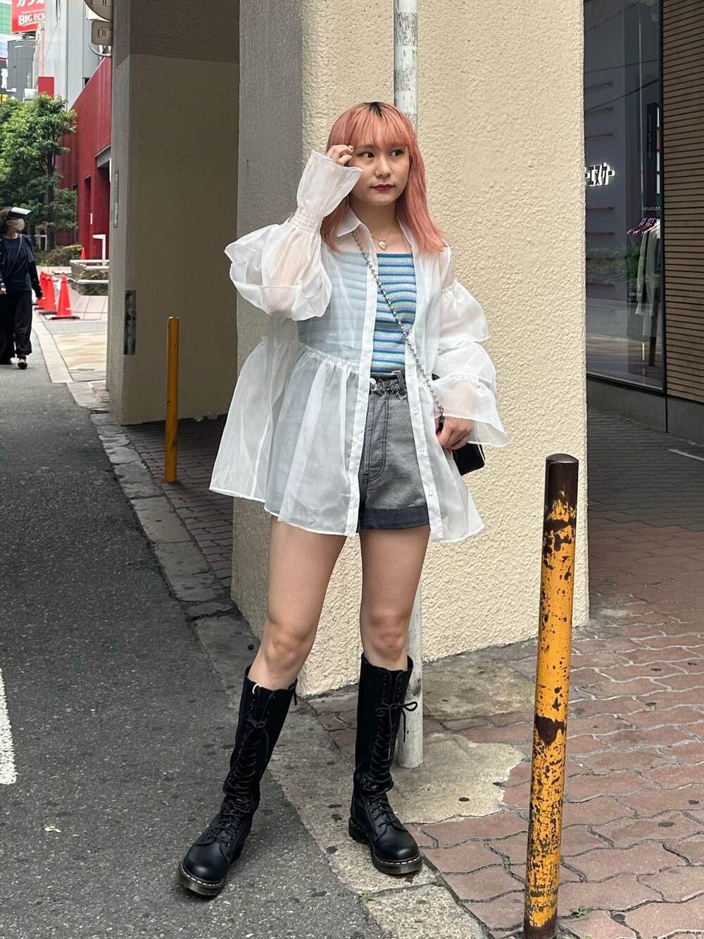 ブラック系のブーツ、ブラック系のデニムパンツ、ホワイト系のシャツ/ブラウスを着用したレディースの夏コーディネートの2枚目の写真