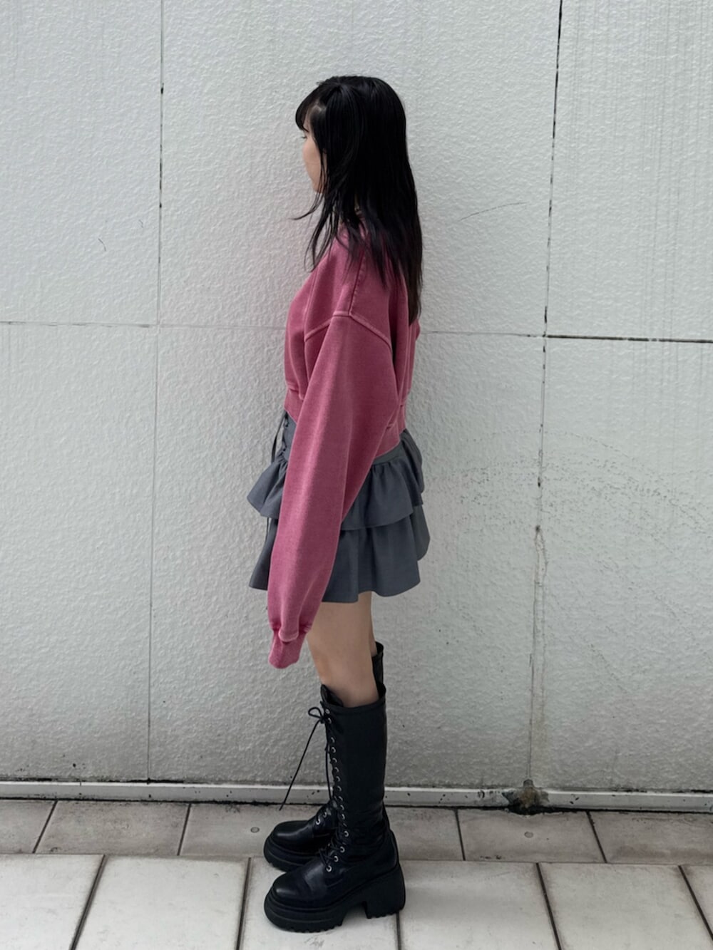 ブラック系のブーツ、ピンク系のスウェット、グレー系のスカートを着用したレディースの冬コーディネートの2枚目の写真
