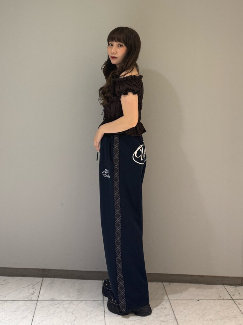 ブラック系のサンダル、ブルー系のその他パンツ、ブラウン系のシャツ/ブラウスを着用したレディースの夏コーディネートの2枚目の写真