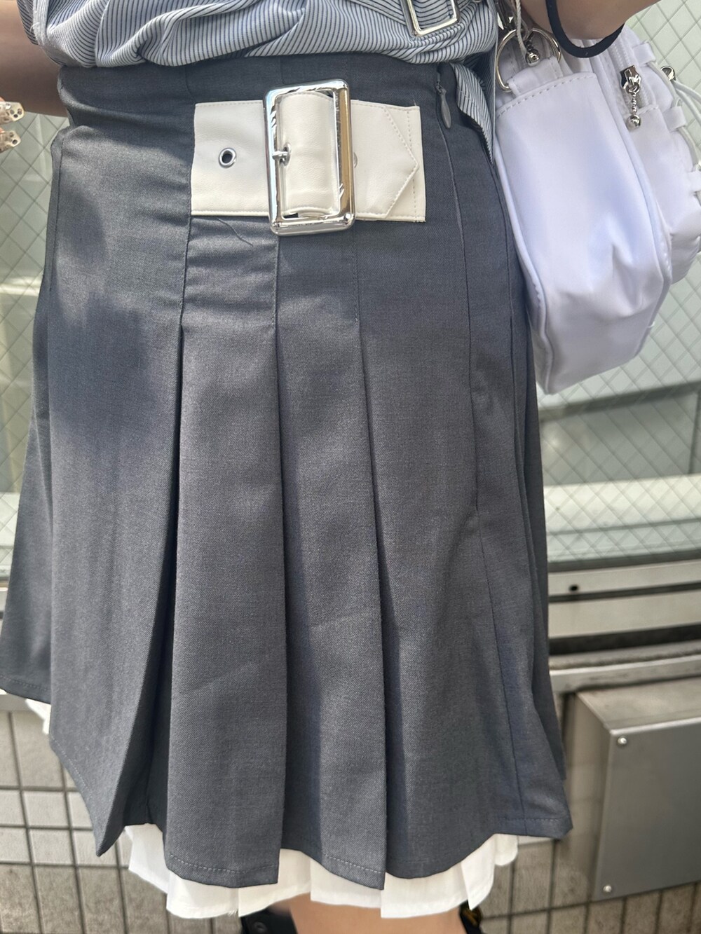 グレー系のスカート、ホワイト系のショルダーバッグ、ブルー系のシャツ/ブラウスを着用したレディースの夏コーディネートの7枚目の写真