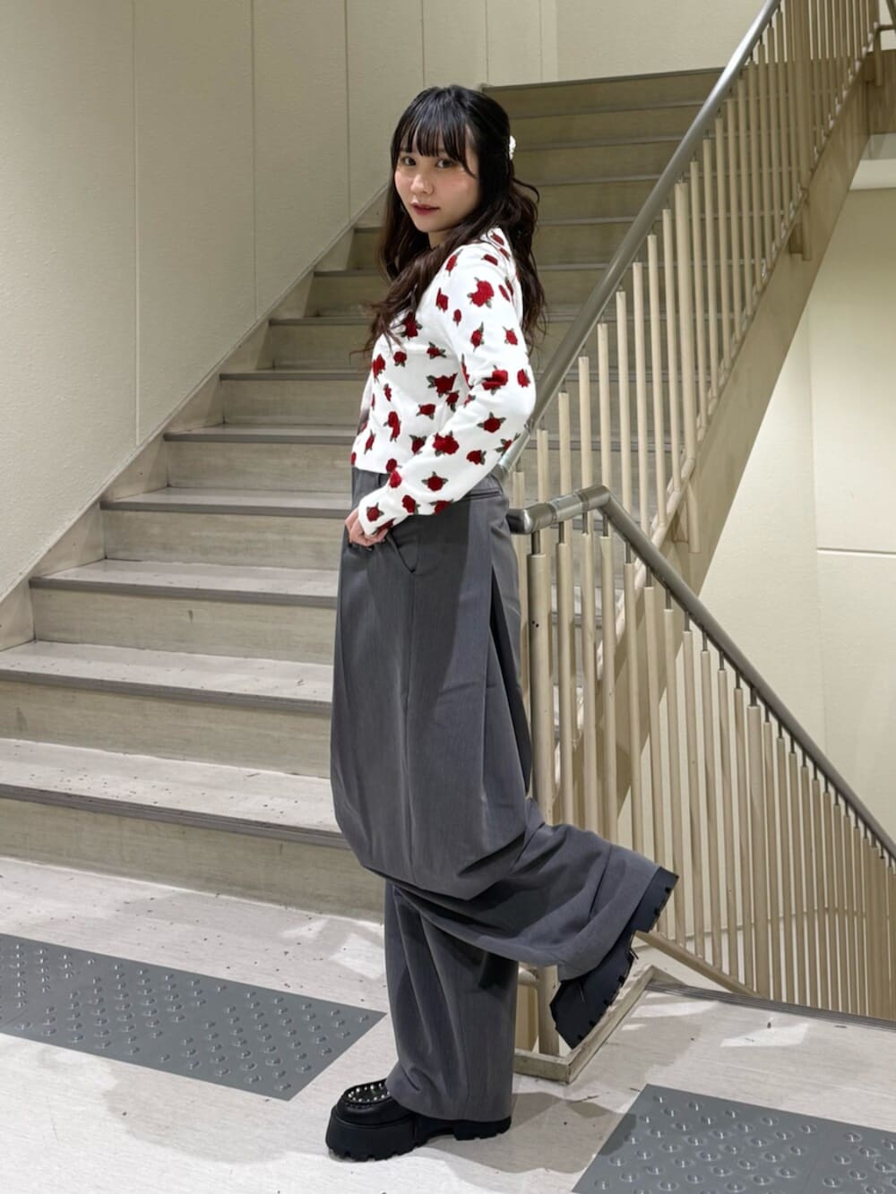 グレー系のスラックス、ホワイト系のカーディガン/ボレロ、ブラック系のローファーを着用したレディースの冬コーディネートの4枚目の写真