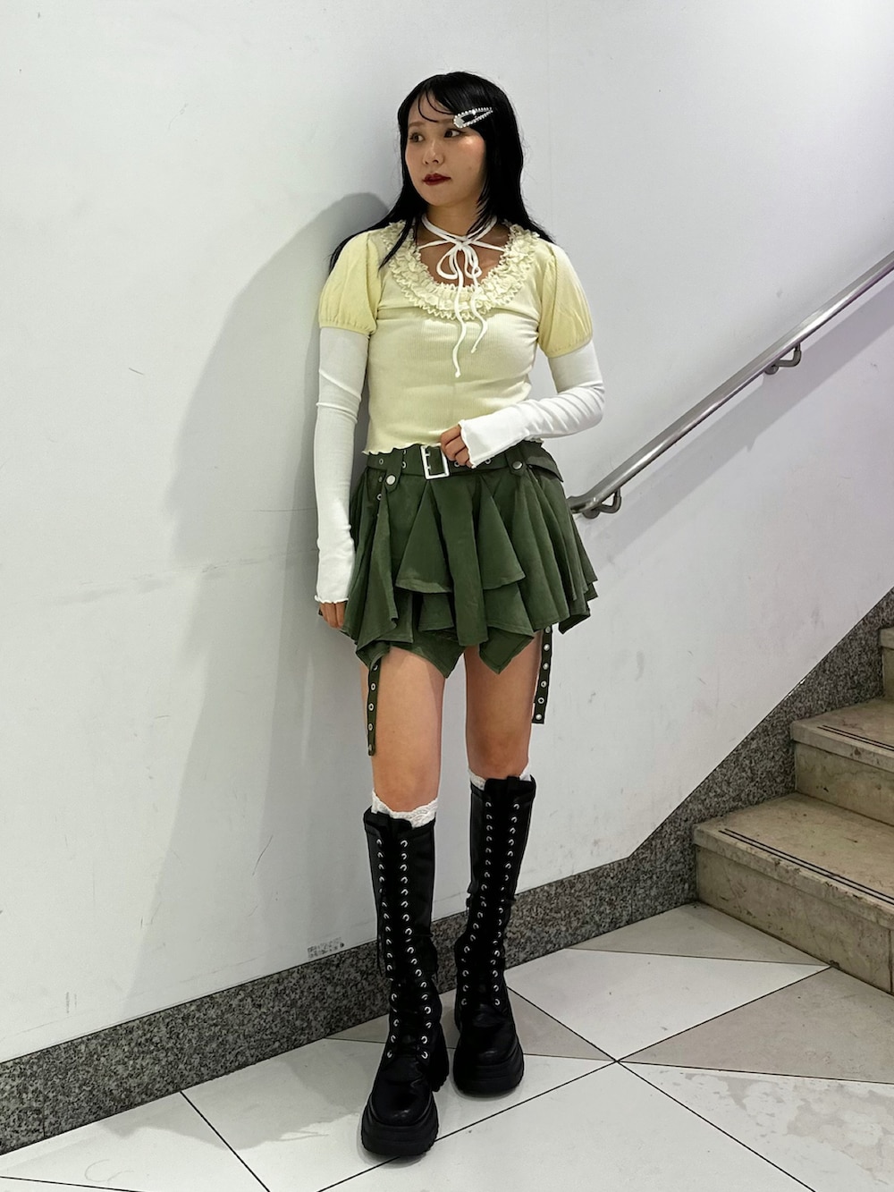 ホワイト系のTシャツ/カットソー、グリーン系のスカート、ブラック系のブーツを着用したレディースの秋コーディネートの2枚目の写真