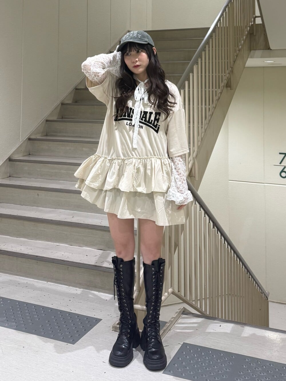 ブラック系のブーツ、ホワイト系のワンピース、ホワイト系のTシャツ/カットソーを着用したレディースの春コーディネートの7枚目の写真