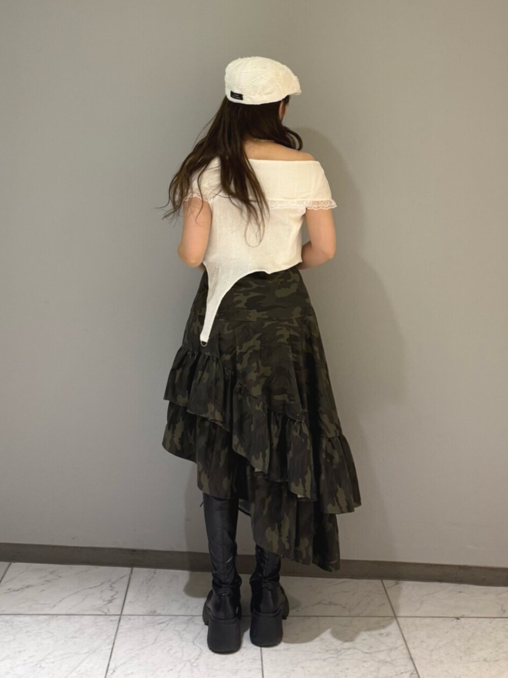 ブラック系のブーツ、ホワイト系のTシャツ/カットソー、グリーン系のスカートを着用したレディースの夏コーディネートの3枚目の写真