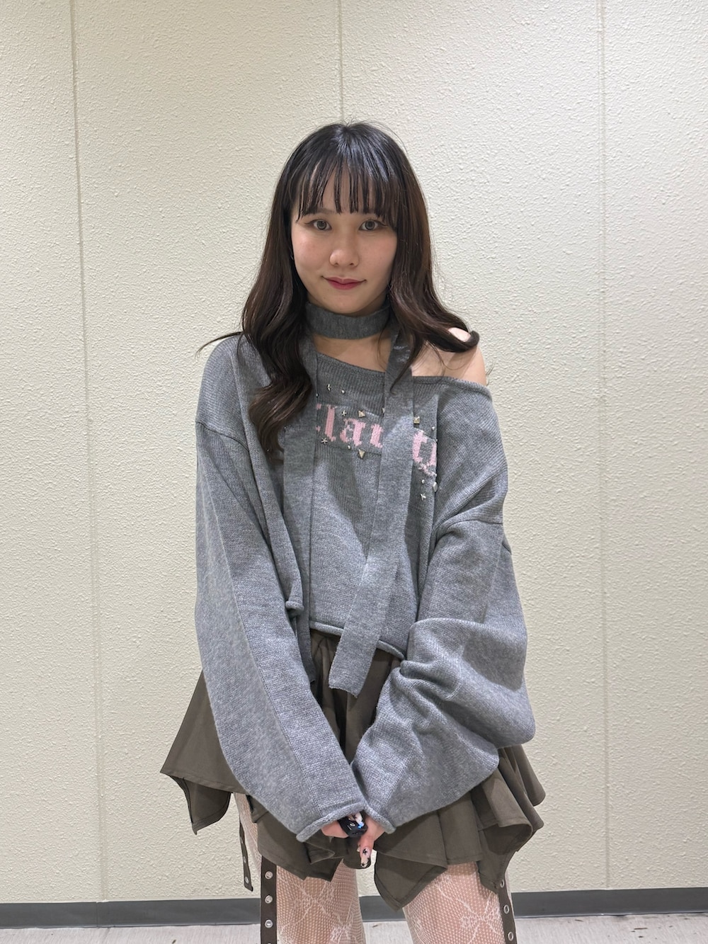 ベージュ系のスカート、グレー系のニット/セーター、ブラック系のブーツを着用したレディースの冬コーディネートの6枚目の写真