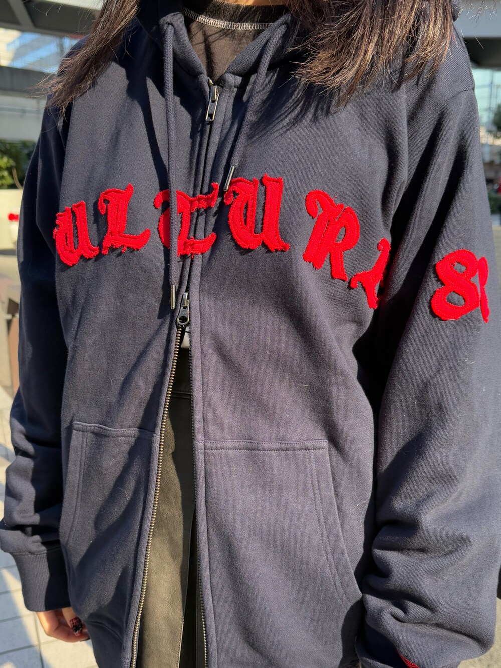 ブルー系のパーカー、ホワイト系のショルダーバッグ、ブラック系のスカートを着用したレディースの冬コーディネートの6枚目の写真