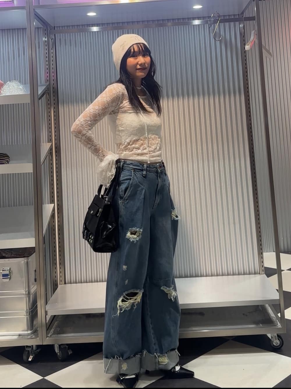 ホワイト系のTシャツ/カットソー、ブルー系のデニムパンツ、ブラック系のハンドバッグを着用したレディースの秋コーディネートの2枚目の写真
