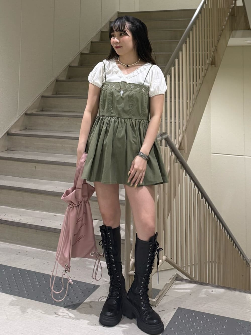 ブラック系のブーツ、ホワイト系のTシャツ/カットソー、グリーン系のチュニックを着用したレディースの春コーディネートの4枚目の写真