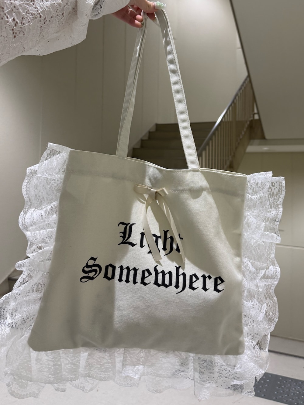 ホワイト系のパーカー、ブラック系のデニムパンツ、ホワイト系のトートバッグを着用したレディースの春コーディネートの9枚目の写真