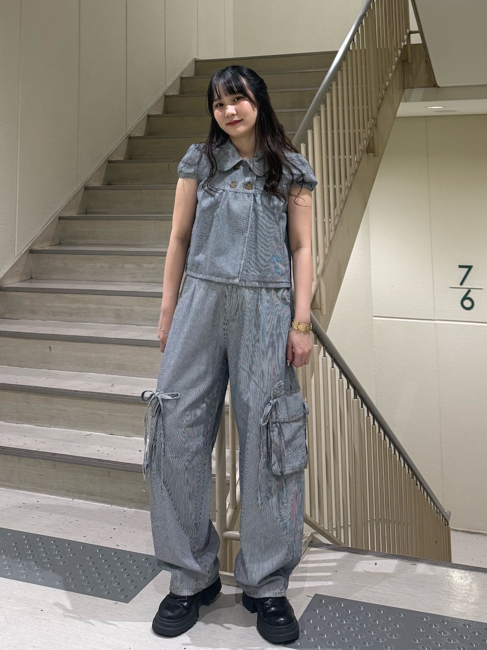 ブラック系のデニムパンツ、ブラック系のブーツ、ブラック系のその他トップスを着用したレディースの春コーディネートの7枚目の写真