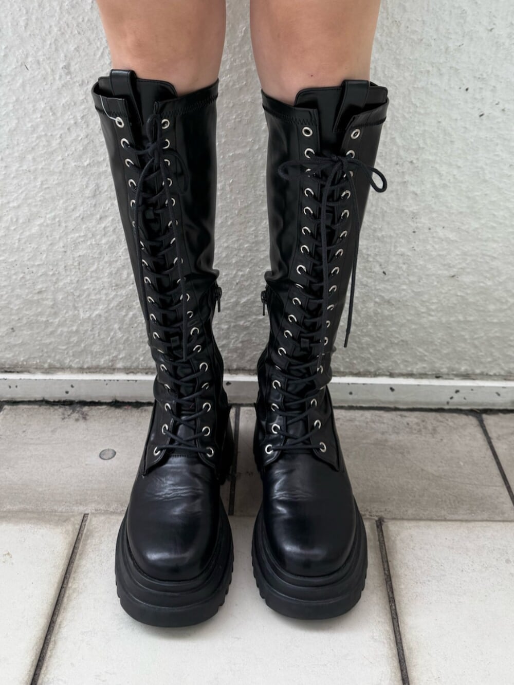 ブラック系のブーツ、ピンク系のスウェット、グレー系のスカートを着用したレディースの冬コーディネートの7枚目の写真