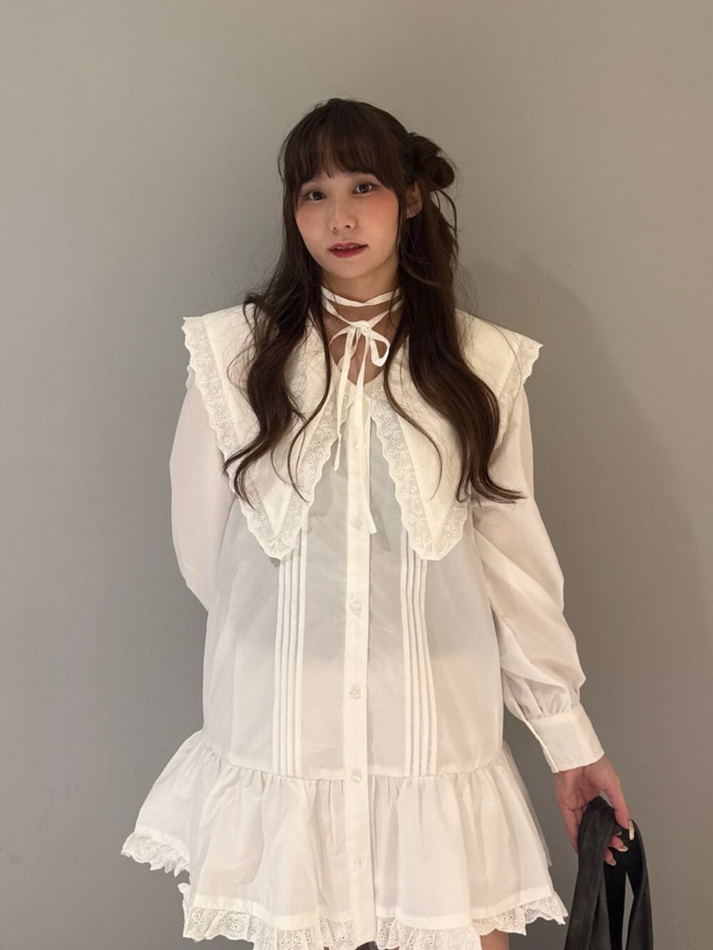 グレー系のトートバッグ、ブラック系のブーツ、ホワイト系のワンピースを着用したレディースの夏コーディネートの5枚目の写真