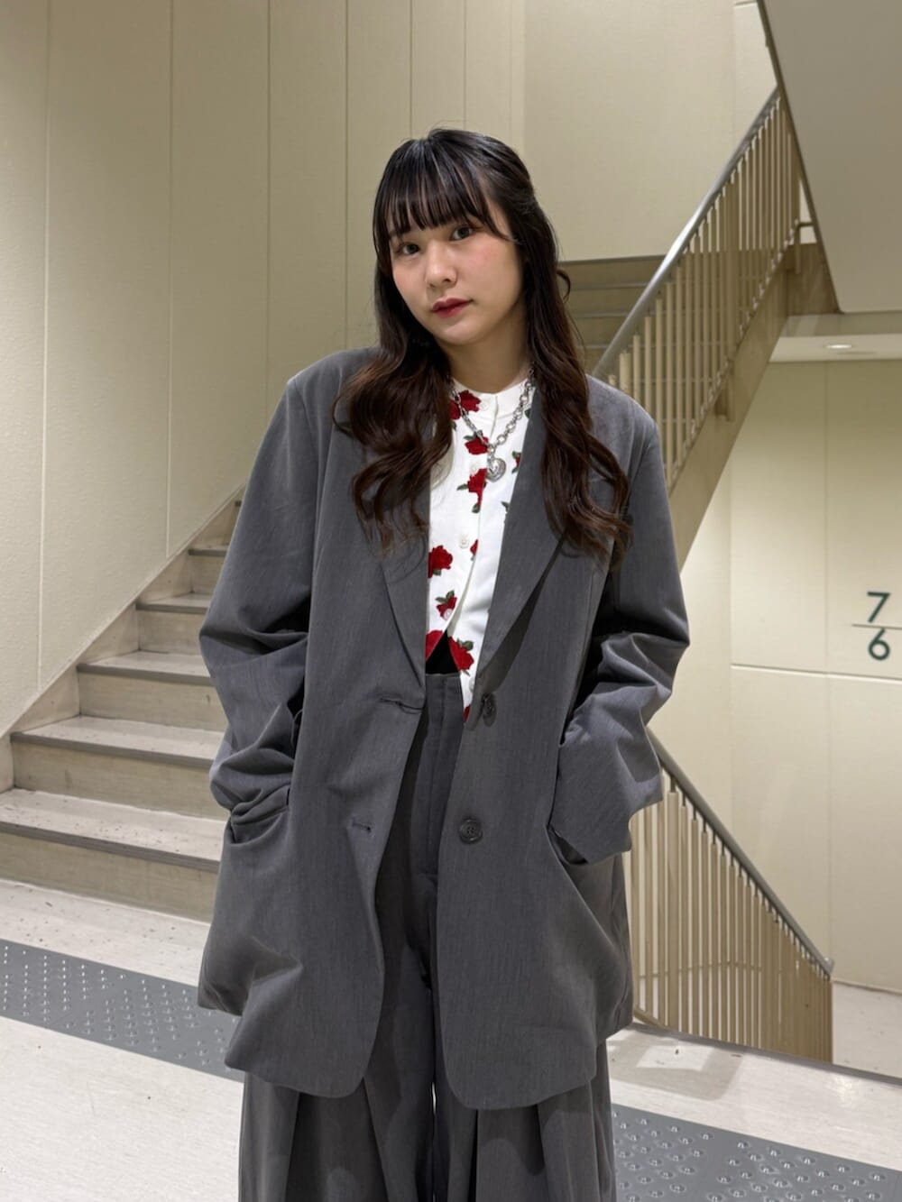 グレー系のスラックス、グレー系のテーラードジャケット、ホワイト系のカーディガン/ボレロを着用したレディースの冬コーディネートの7枚目の写真