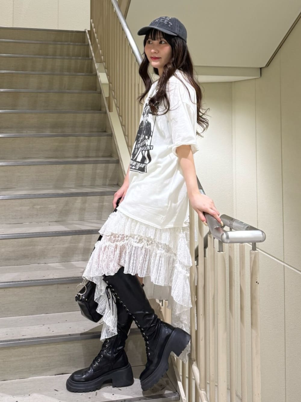 ブラック系のブーツ、ホワイト系のTシャツ/カットソー、ブラック系のハンドバッグを着用したレディースの春コーディネートの2枚目の写真