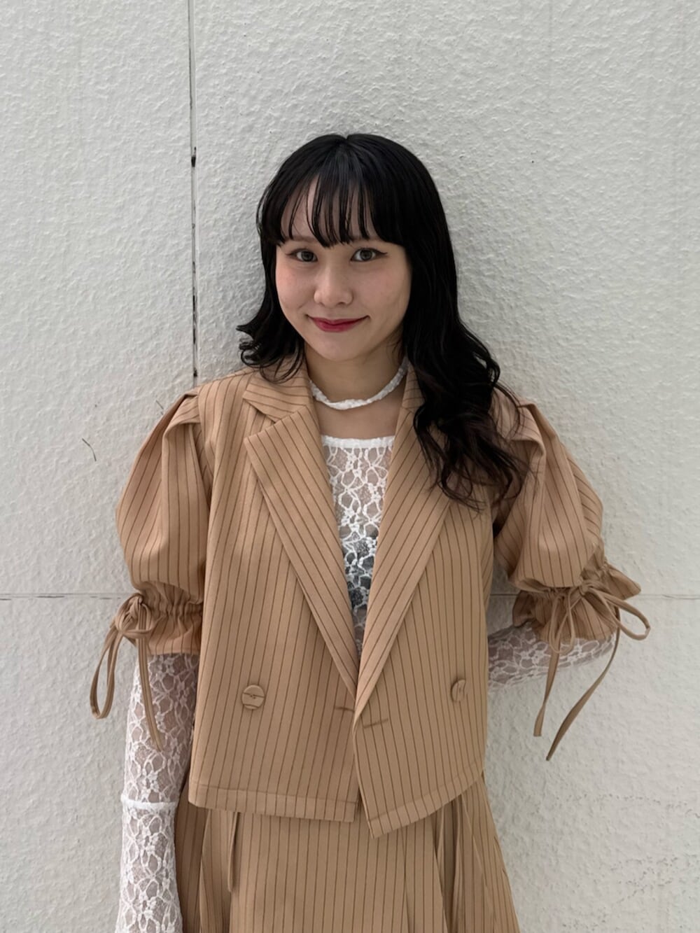 ブラック系のブーツ、ホワイト系のTシャツ/カットソー、ベージュ系のテーラードジャケットを着用したレディースの冬コーディネートの6枚目の写真