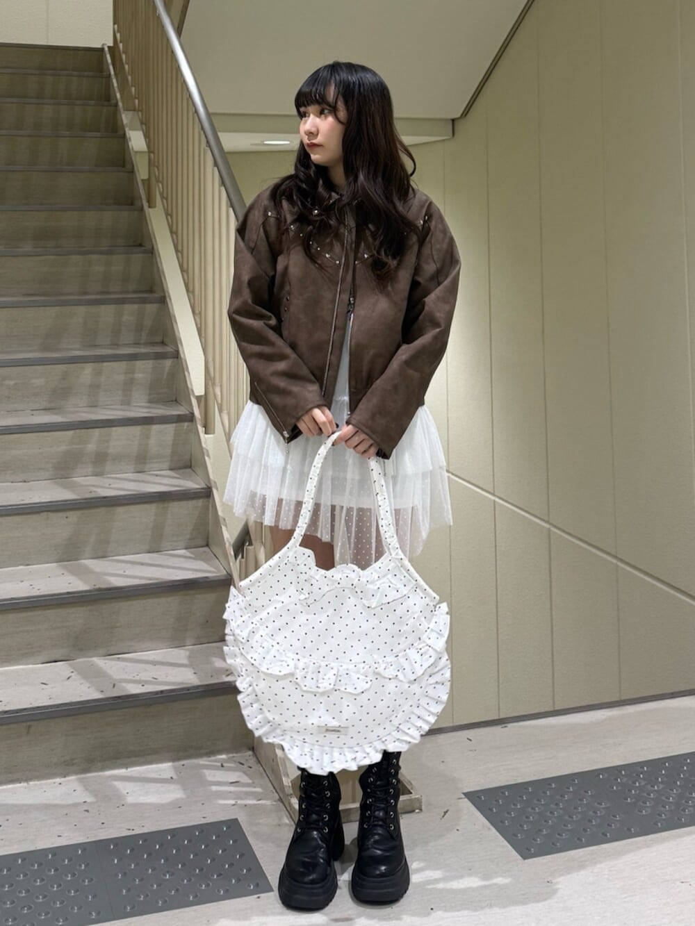 ブラック系のブーツ、ブラウン系のブルゾン、ホワイト系のワンピースを着用したレディースの冬コーディネートの2枚目の写真