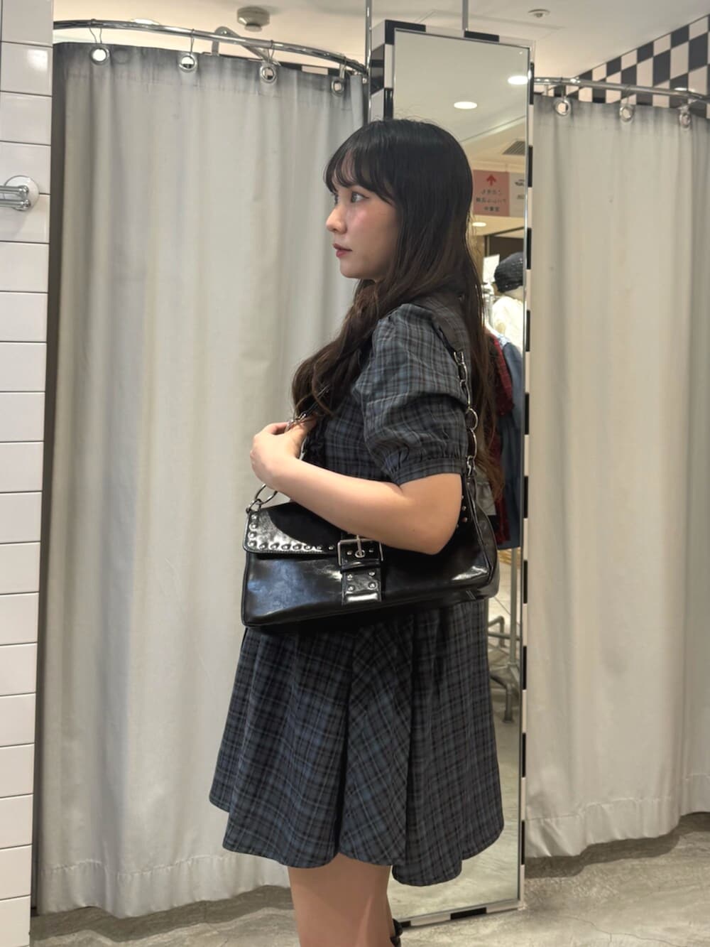ブラック系のハンドバッグ、ブラック系のブーツ、ブルー系のワンピースを着用したレディースの夏コーディネートの5枚目の写真