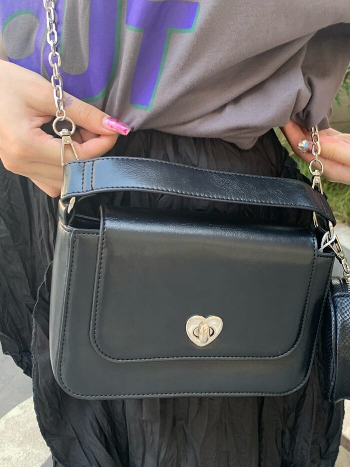 ブラック系のワンピース、ブラック系のハンドバッグ、シルバー系のネックレスを着用したレディースの夏コーディネートの7枚目の写真