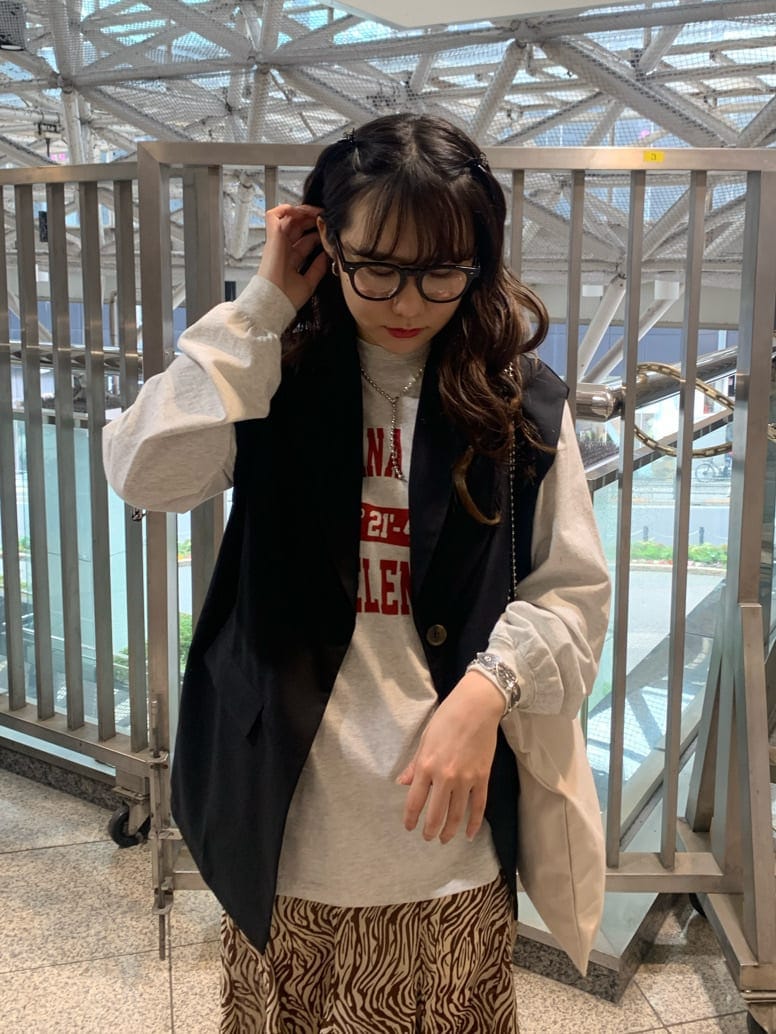 ブラック系のベスト、ホワイト系のトートバッグ、その他のスカートを着用したレディースの春コーディネートの3枚目の写真