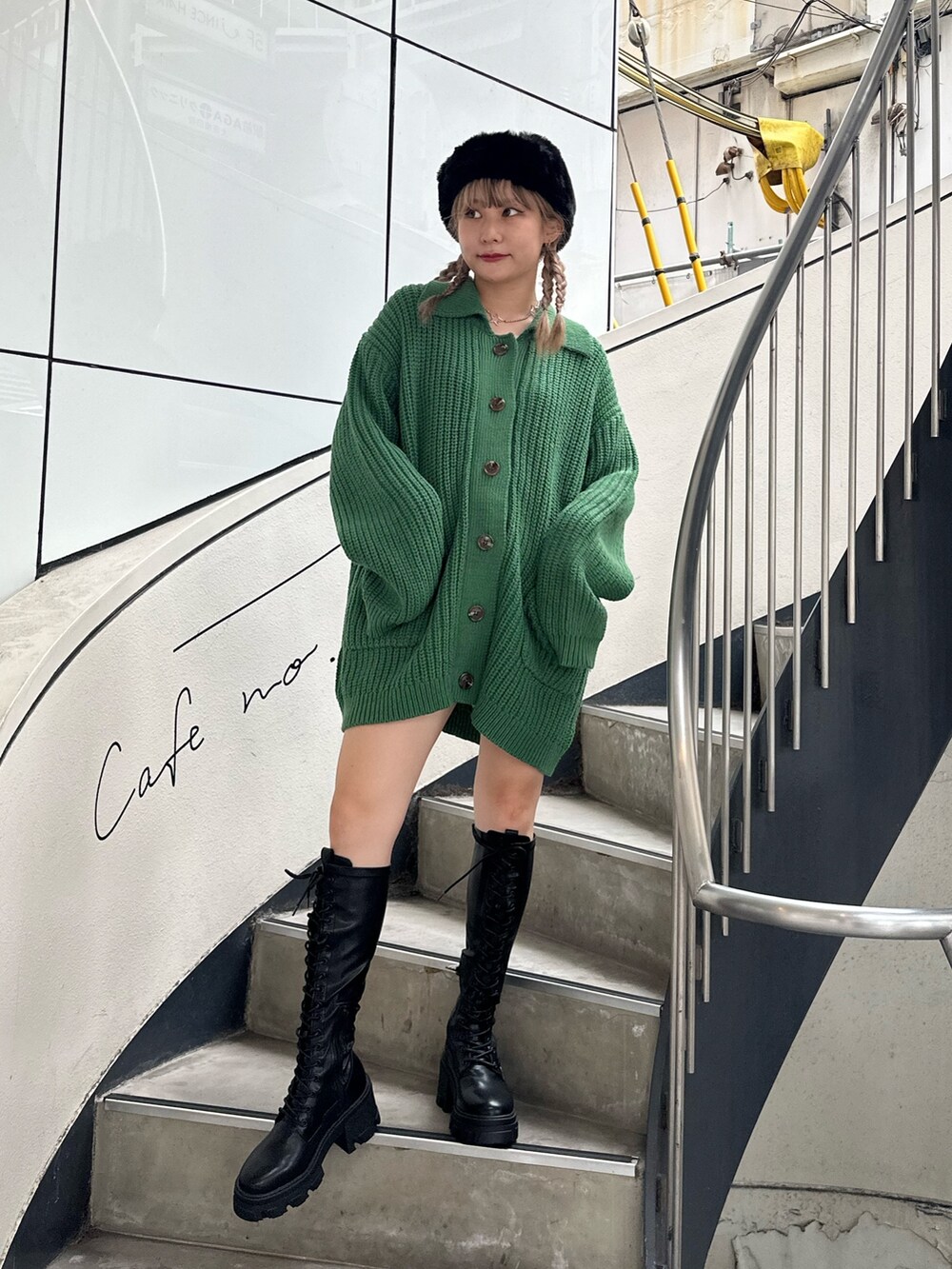 グリーン系のカーディガン/ボレロ、ブラック系のブーツ、シルバー系のネックレスを着用したレディースの秋コーディネートの2枚目の写真