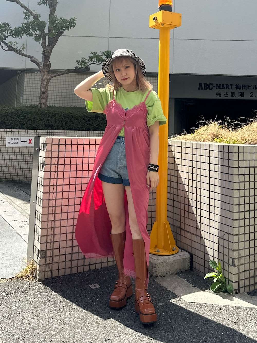 グリーン系のTシャツ/カットソー、ブルー系のデニムパンツ、ピンク系のワンピースを着用したレディースの春コーディネートの2枚目の写真