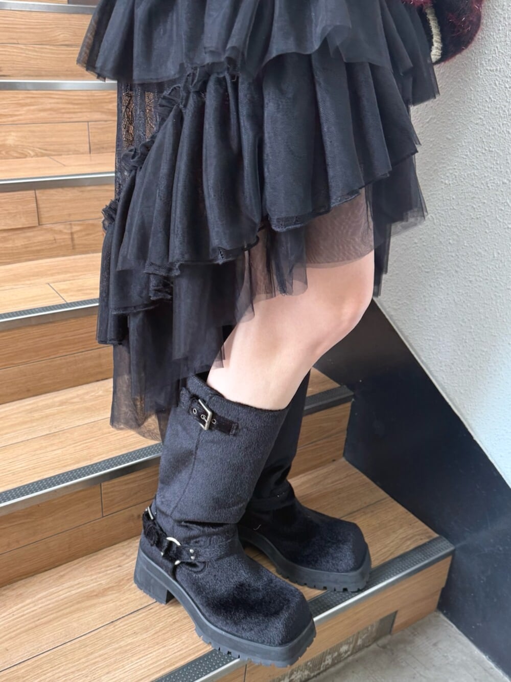 ブラック系のブーツ、ブラック系のスカート、ブラック系のニット/セーターを着用したレディースの夏コーディネートの7枚目の写真