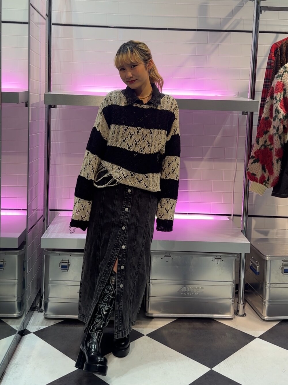 ブラック系のニット/セーター、ブラック系のワンピース、ブラック系のブーツを着用したレディースの冬コーディネートの5枚目の写真