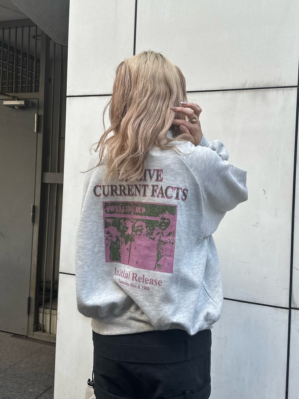 グレー系のスウェット、ブラック系のスカート、ブラック系のハンドバッグを着用したレディースの秋コーディネートの5枚目の写真