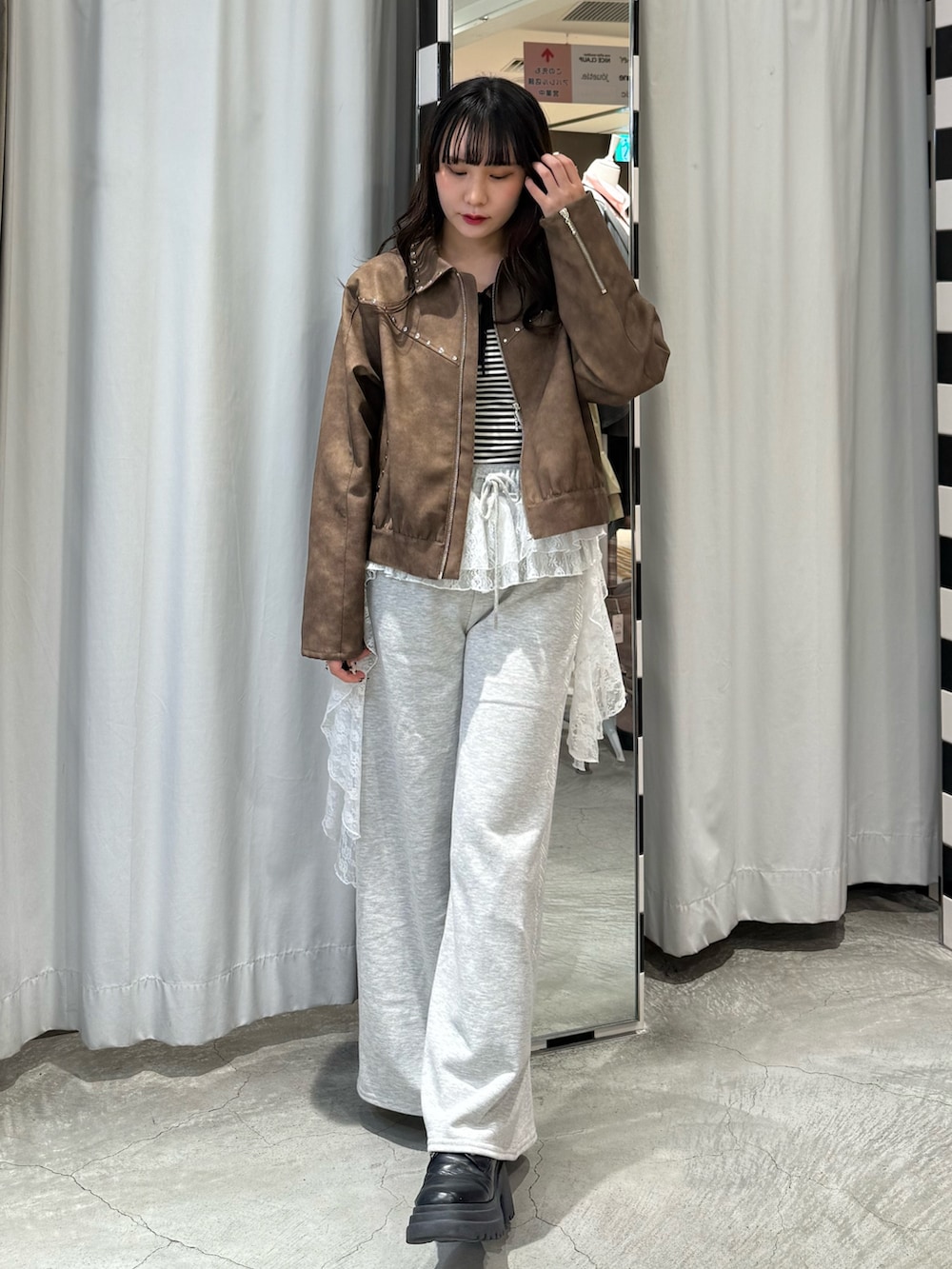 ブラック系のニット/セーター、ブラウン系のブルゾン、グレー系のスウェットパンツを着用したレディースの冬コーディネートの2枚目の写真