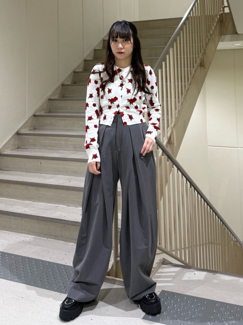 グレー系のスラックス、ホワイト系のカーディガン/ボレロ、ブラック系のローファーを着用したレディースの冬コーディネートの6枚目の写真