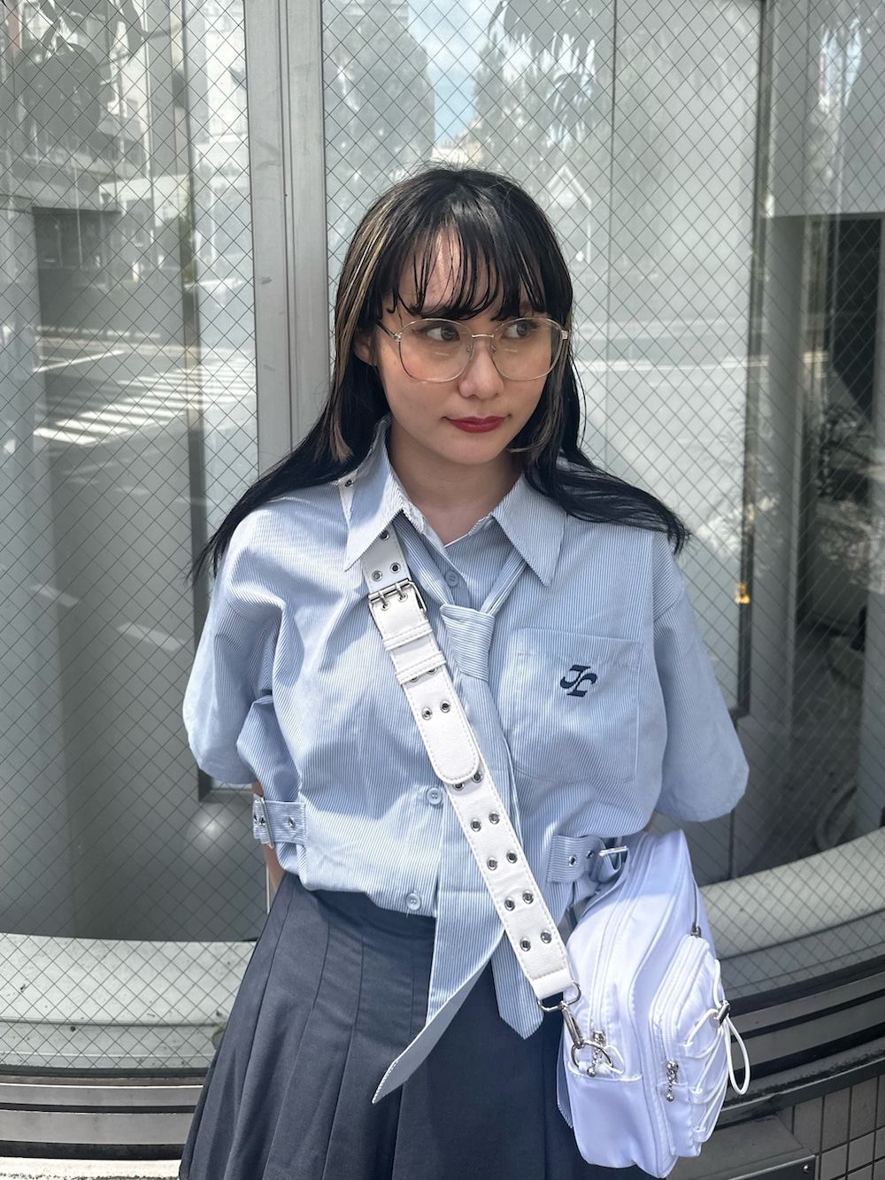 グレー系のスカート、ホワイト系のショルダーバッグ、ブルー系のシャツ/ブラウスを着用したレディースの夏コーディネートの4枚目の写真