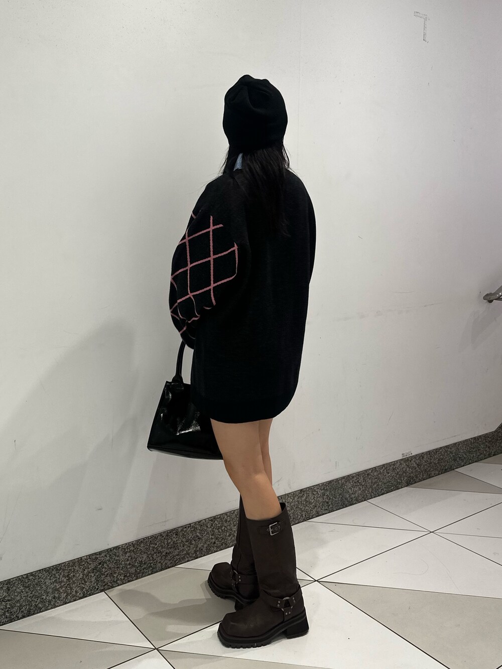 ブラック系のニット/セーター、ブラウン系のブーツ、ブルー系のシャツ/ブラウスを着用したレディースの秋コーディネートの2枚目の写真