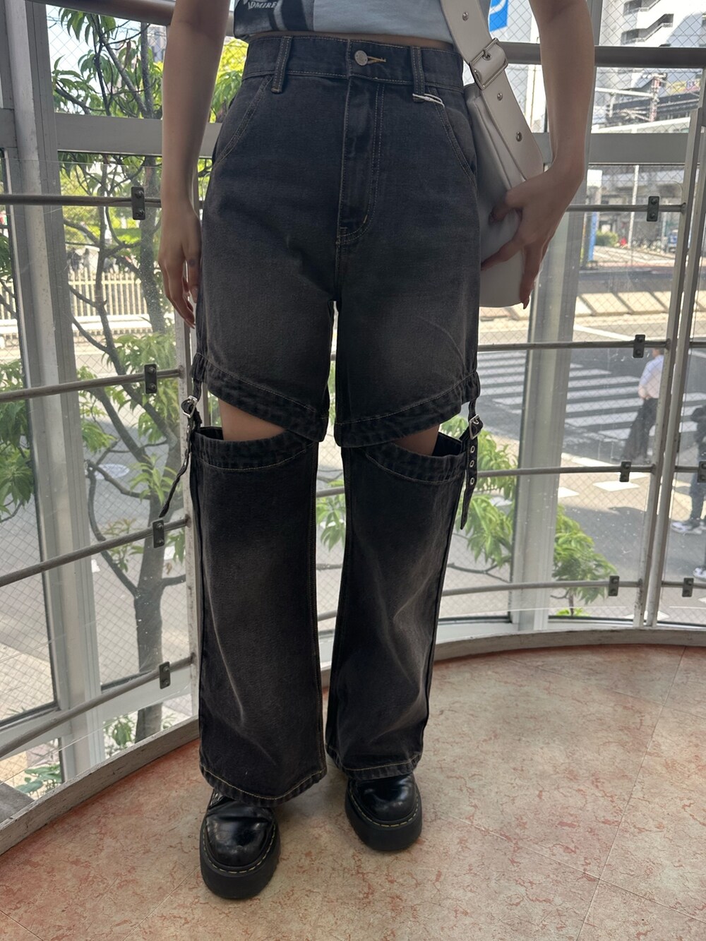 ブラック系のデニムパンツ、ホワイト系のショルダーバッグ、ブルー系のTシャツ/カットソーを着用したレディースの春コーディネートの6枚目の写真