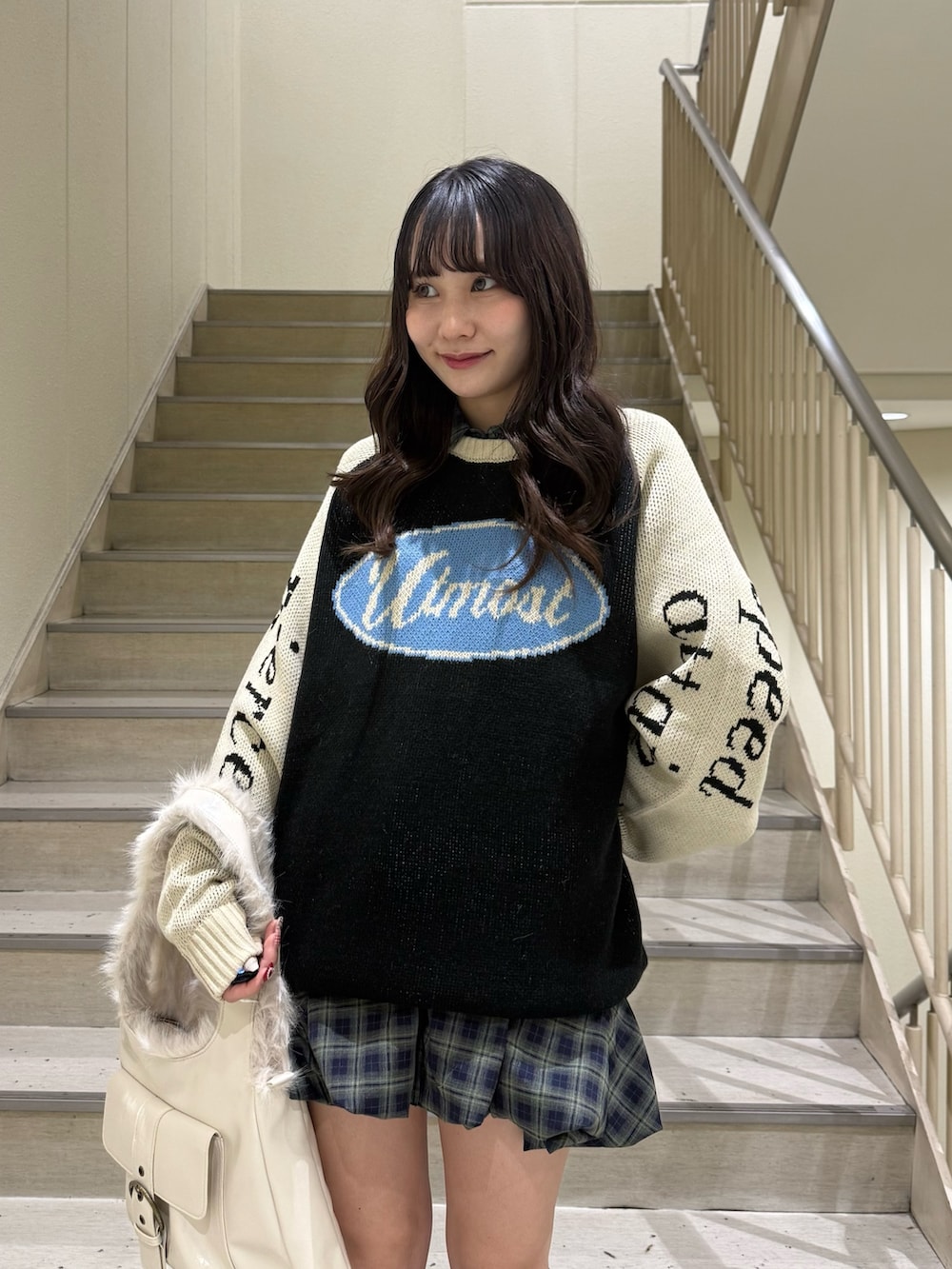 ブラック系のニット/セーター、グリーン系のワンピース、ホワイト系のハンドバッグを着用したレディースの冬コーディネートの8枚目の写真