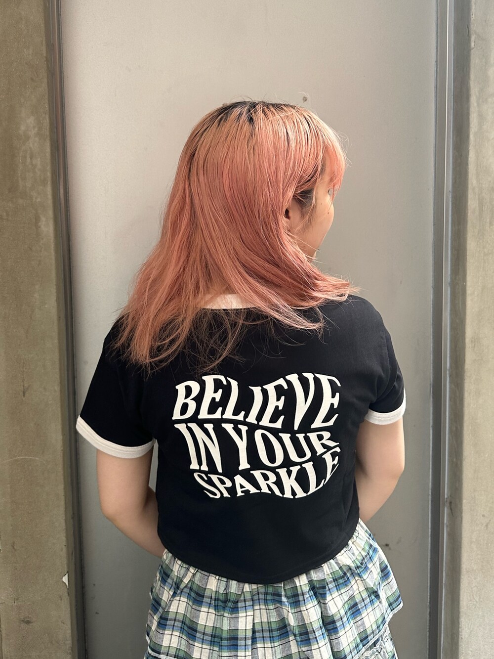 ブラック系のハンドバッグ、ブラック系のTシャツ/カットソー、グリーン系のスカートを着用したレディースの夏コーディネートの5枚目の写真