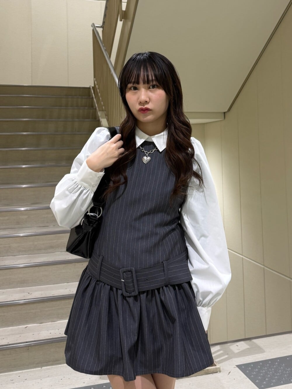 ブラック系のハンドバッグ、グレー系のシャツワンピース、ブルー系のローファーを着用したレディースの冬コーディネートの6枚目の写真