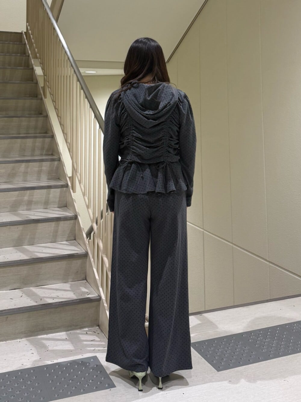 グレー系のスウェットパンツ、ブラック系のパーカー、グリーン系のパンプスを着用したレディースの春コーディネートの3枚目の写真