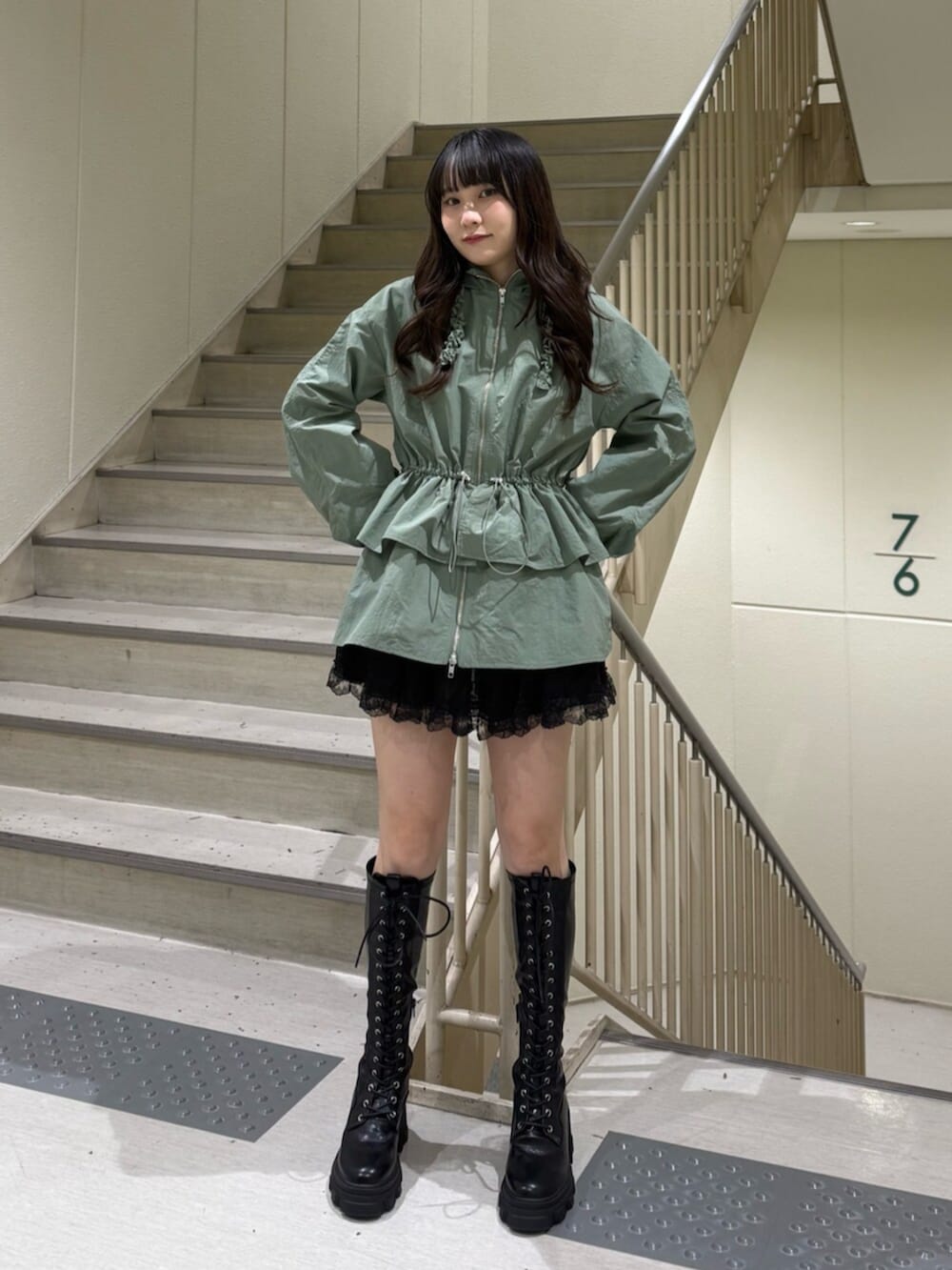 ブラック系のブーツ、グリーン系のナイロンジャケット、ブラック系のその他パンツを着用したレディースの春コーディネートの3枚目の写真