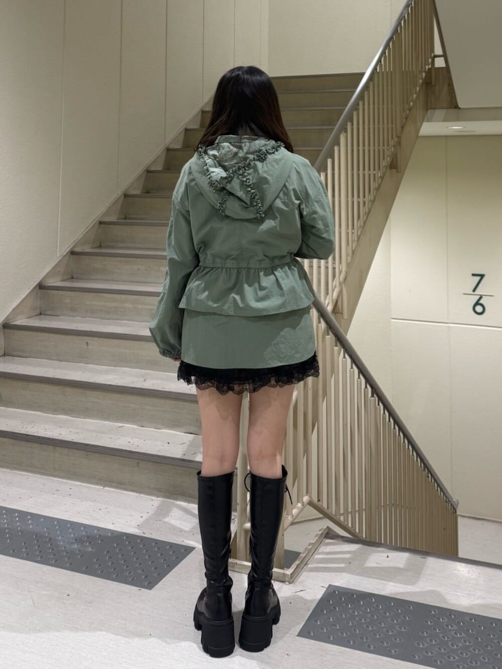 ブラック系のブーツ、グリーン系のナイロンジャケット、ブラック系のその他パンツを着用したレディースの春コーディネートの5枚目の写真