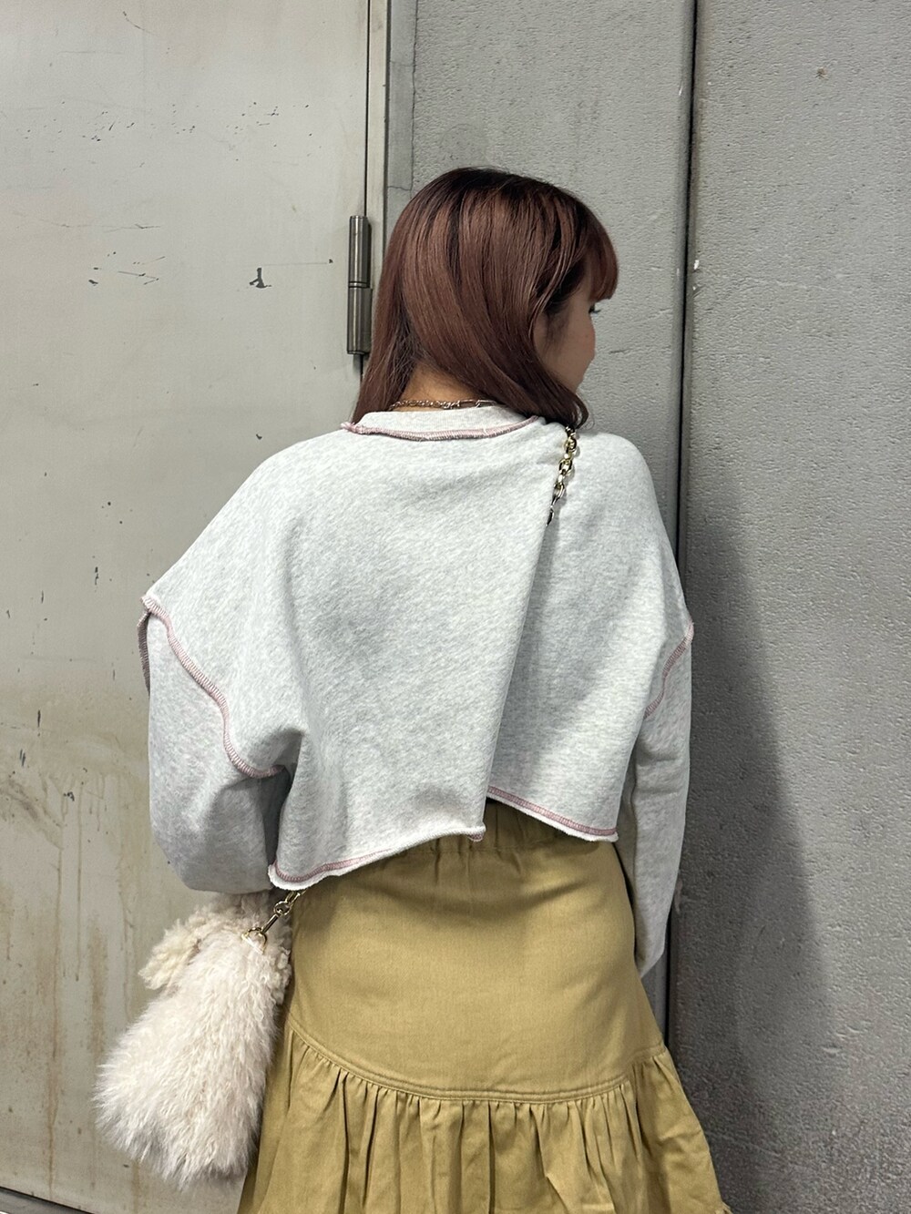 グレー系のスウェット、ホワイト系のハンドバッグ、ベージュ系のスカートを着用したレディースの冬コーディネートの5枚目の写真