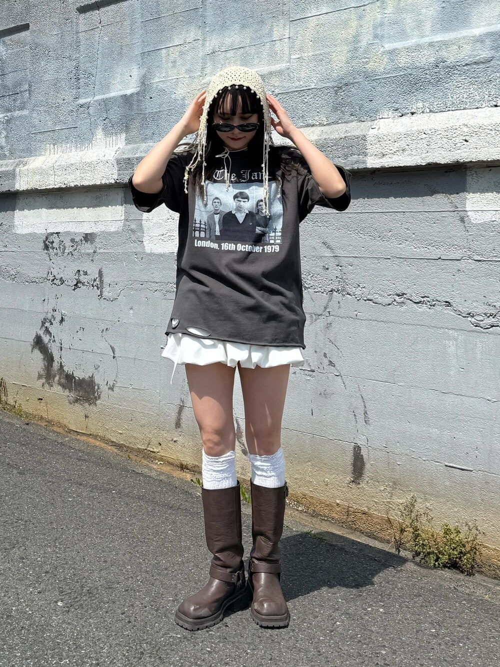 ブラウン系のブーツ、ブラック系のTシャツ/カットソー、ホワイト系のスカートを着用したレディースの春コーディネートの4枚目の写真